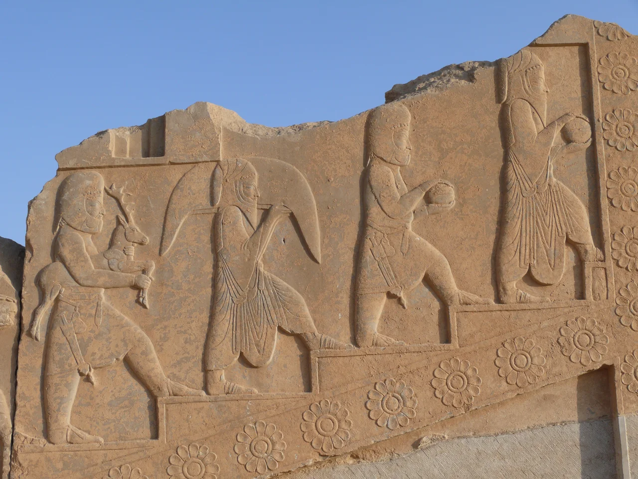 Priests procession at Persepolis. This relief is one of a group of several showing the same kind of procession scene. it decorates the Tachara, Darius the Great's private palace at Persepolis, Iran. According to Werner Dutz, it shows Median and Arachosian priests carrying various gifts and animals for a ritual of sacrifice. During Achaemenian time, Zoroastrism was under a primary form, resulting in the main practice of Mazdeism. 2 Lakes were considered as holy: Hamun-e Orumyeh in Media (Now in Azarbaidjan-e Gharbi province), and Hamun-e Halmand in Arachosia (now at the border between Iran and Afghanistan). It could explain why are the priests medians and Arachosians, identified with their clothings and hats.
But controversies also exist, and some scholars do not think the relief shows priests, but servants at to the royal court bringing the necessary for the royal dinners. Achaemenian dinners were very important political ceremonies, and the possibility exist that this reliefs was made to remind the magnifiscence of these dinners where very few priivileged nobles were invited according to the king's will or agenda.
Taken in Persepolis, City of Marvdasht, Province of Fars, Iran, April 2008.